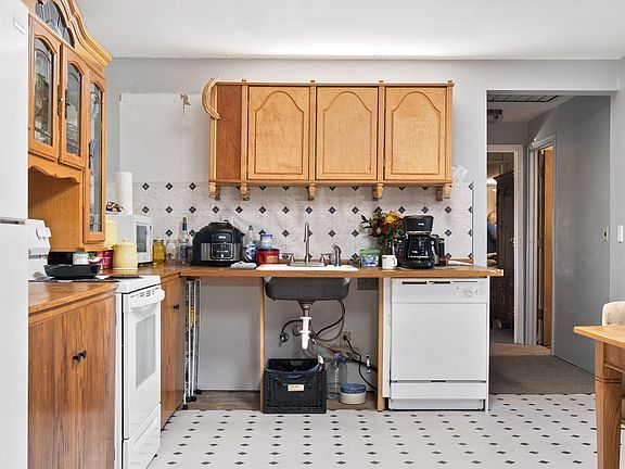A kitchen with a sink , stove , dishwasher and refrigerator.