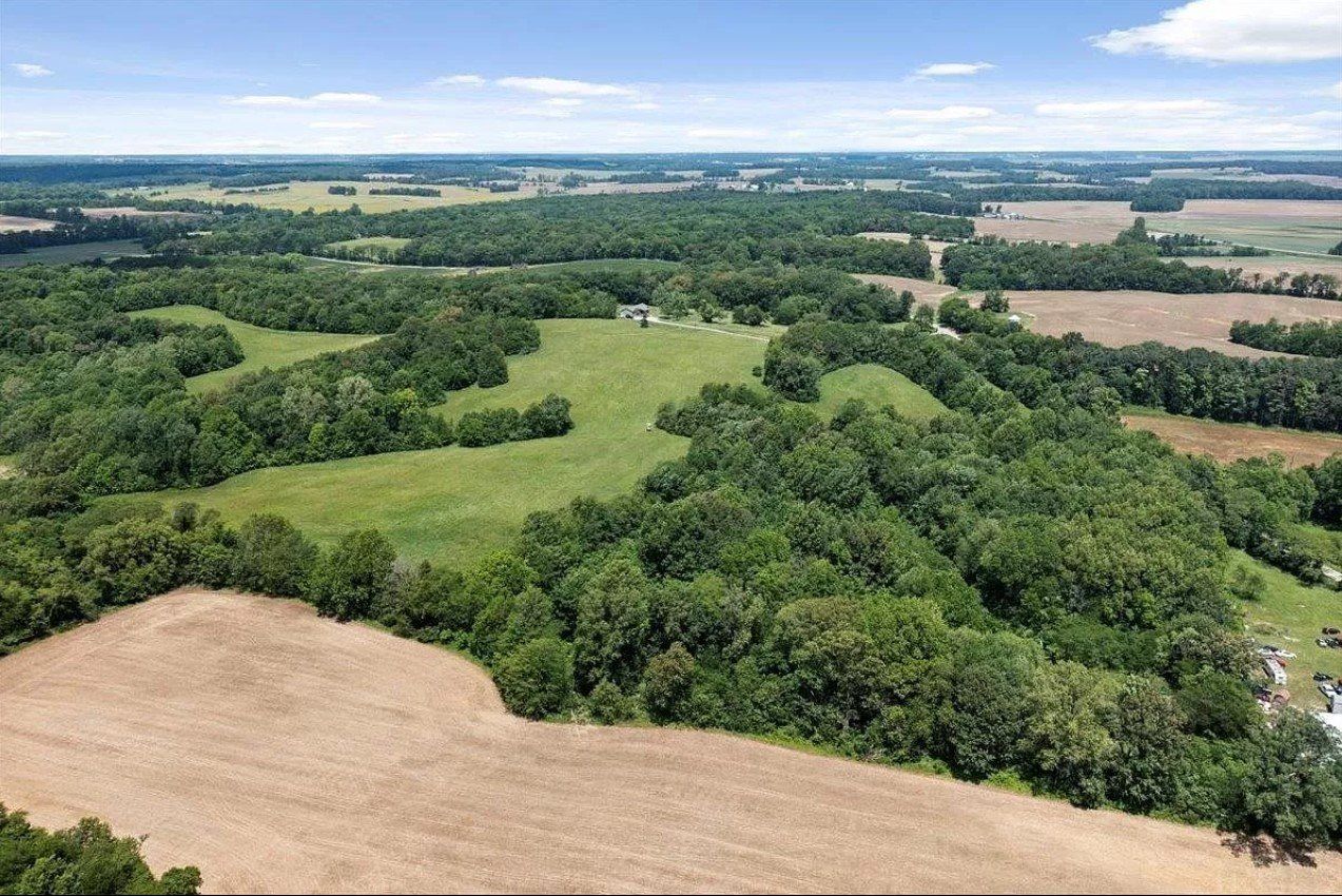 An aerial view of a lush green field surrounded by trees and fields.