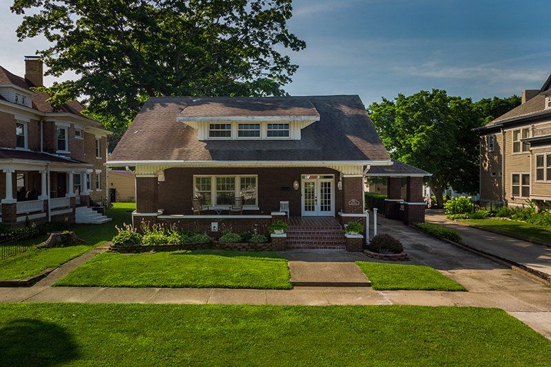 An aerial view of a house with a large lawn in front of it.