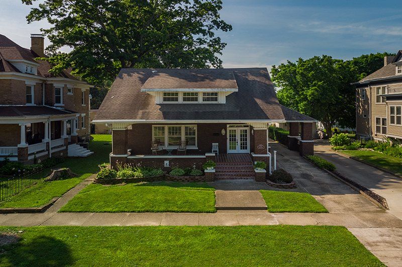 An aerial view of a house with a large lawn in front of it.