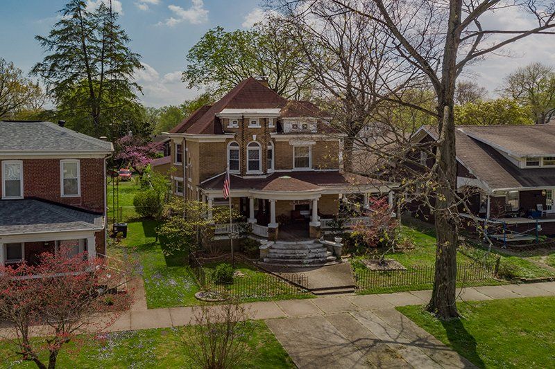 An aerial view of a residential neighborhood with a large house in the middle.