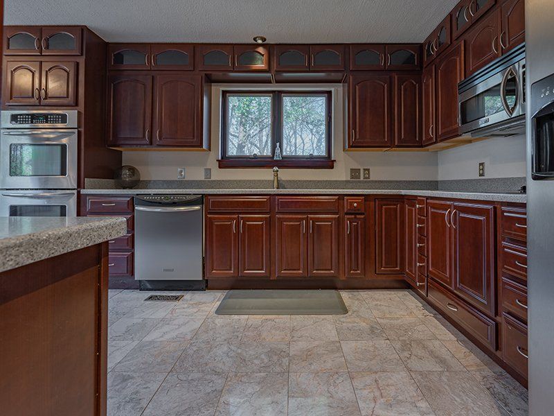 A kitchen with wooden cabinets and stainless steel appliances