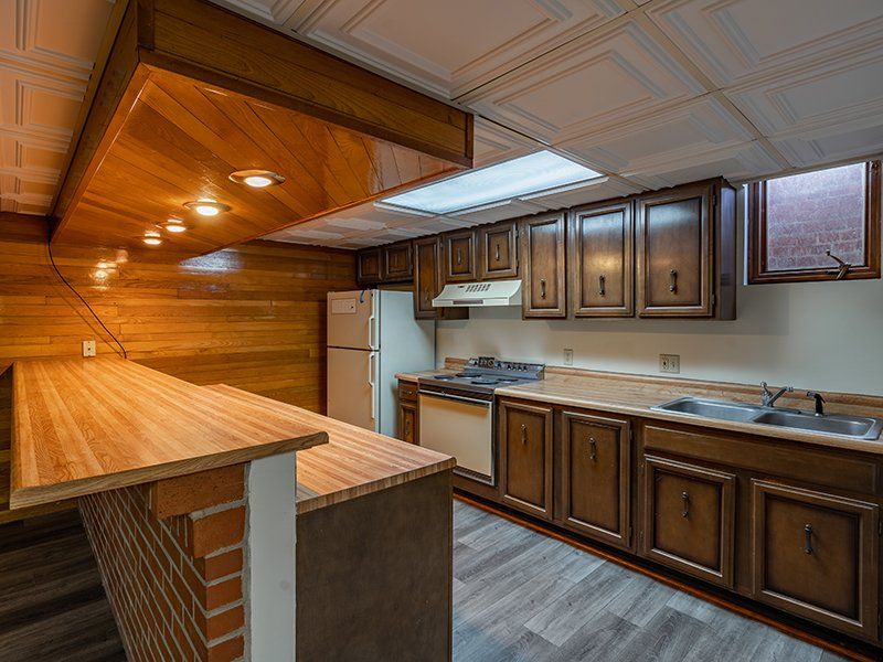 A kitchen with wooden cabinets and a wooden counter top