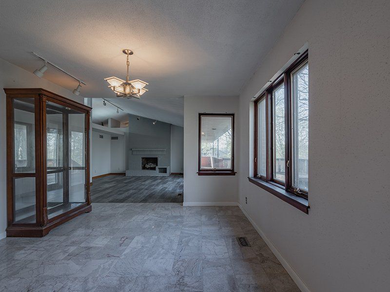 A large empty room with a lot of windows and a fireplace.