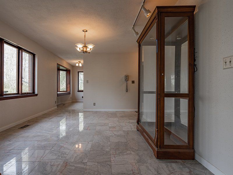 There is a glass cabinet in the middle of the room.