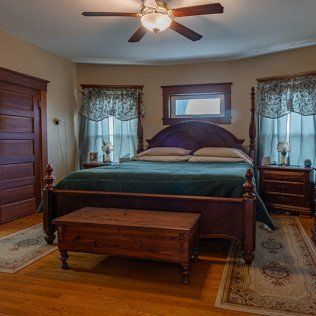 A bedroom with a bed and a ceiling fan