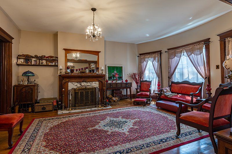 A living room with a fireplace , couch , chairs and a rug.