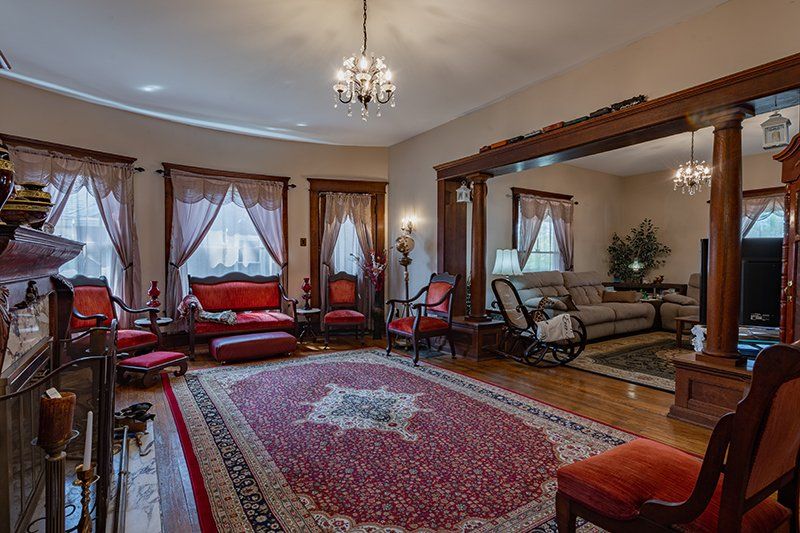 A living room filled with furniture and a red rug.