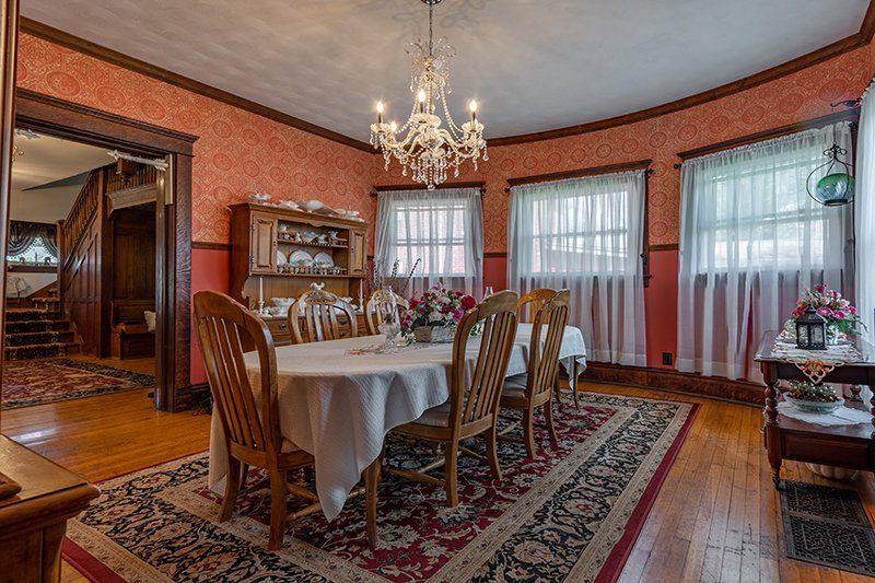 A dining room with a table and chairs and a chandelier.