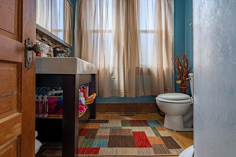 A bathroom with a toilet , sink , and rug.