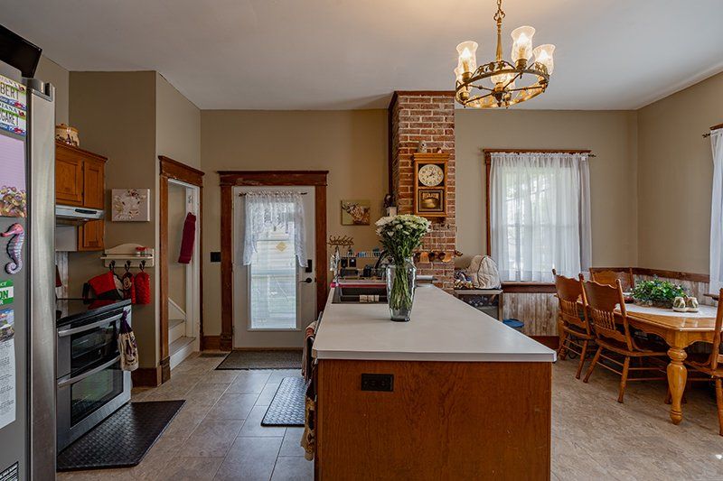A kitchen with a large island in the middle and a clock on the wall.