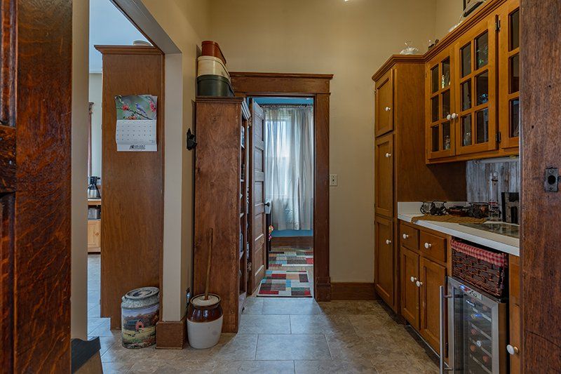 A kitchen with wooden cabinets , a sink , and a refrigerator.