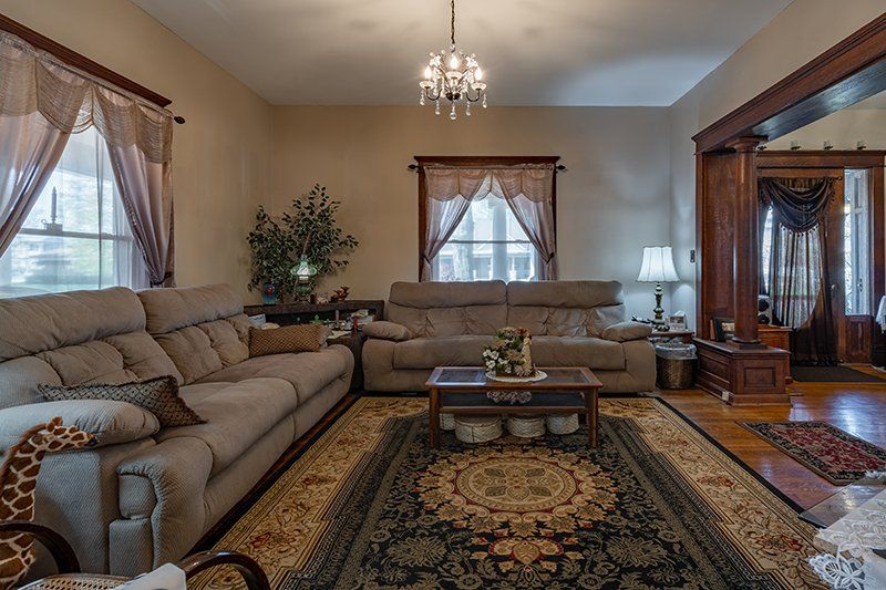 A living room with two couches , a coffee table , and a rug.