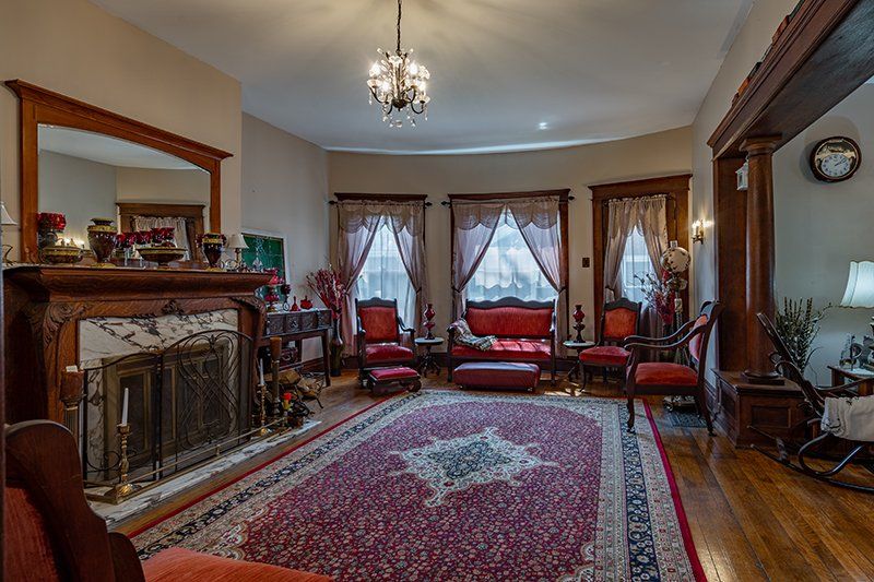 A living room with a fireplace , couch , chairs and a rug.