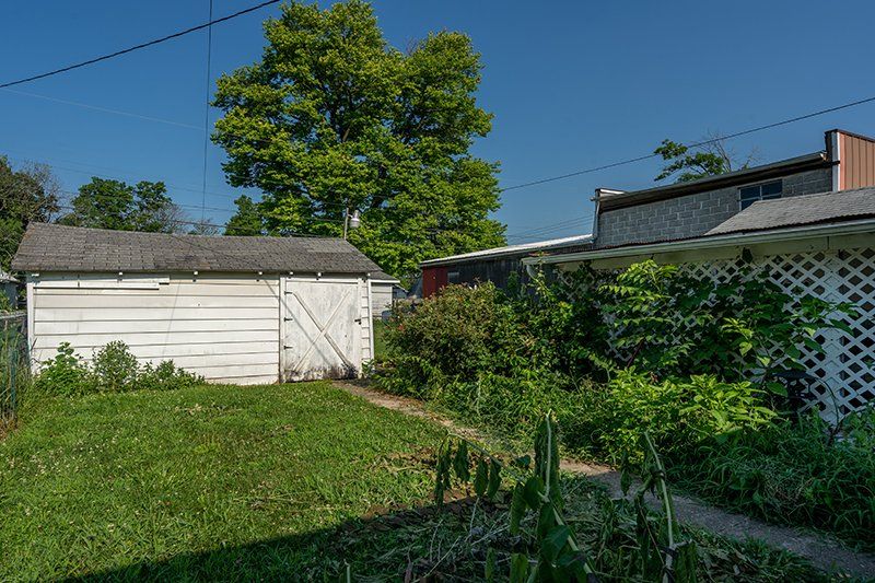 There is a shed in the backyard of a house.