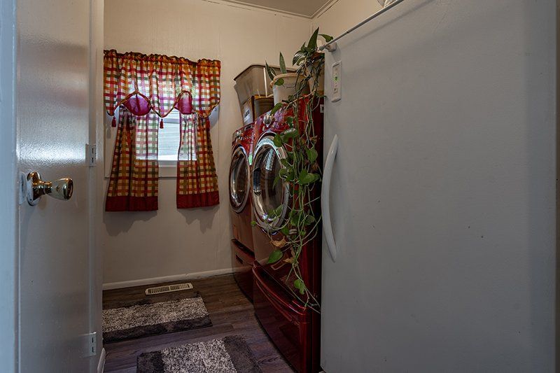 A laundry room with a washer and dryer and a refrigerator.