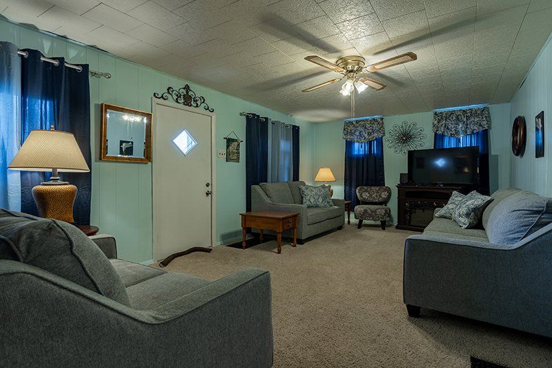 A living room filled with furniture and a ceiling fan.