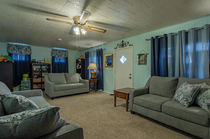 A living room with two couches and a ceiling fan.
