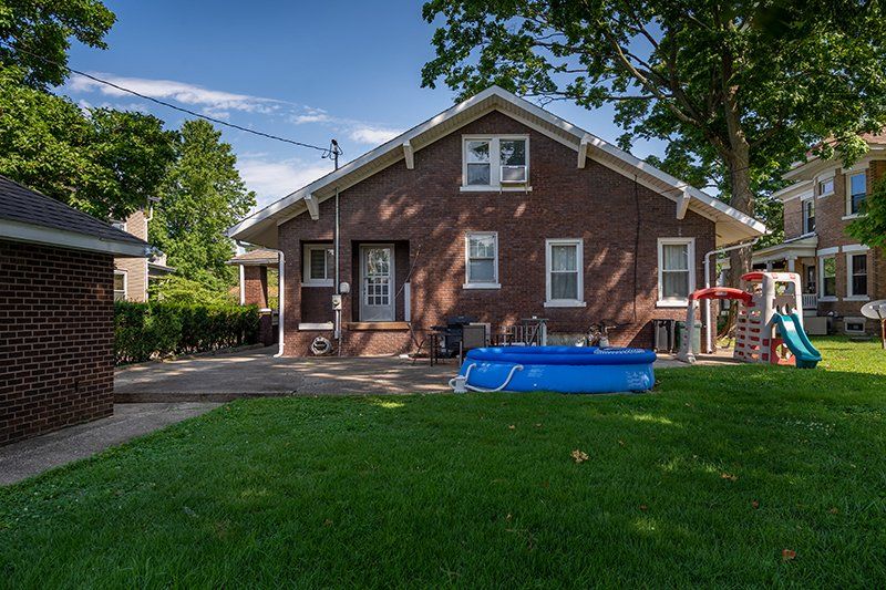 A large brick house with a pool in the backyard.