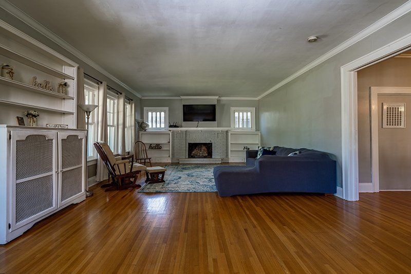 A living room with a couch , chair , fireplace and television.