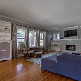 A living room with a couch , chair , fireplace and television.