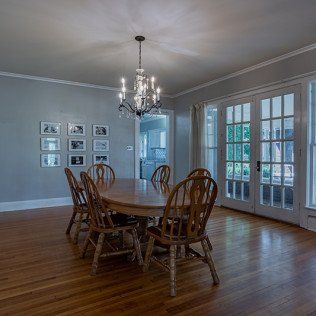 A dining room with a table and chairs and a chandelier.