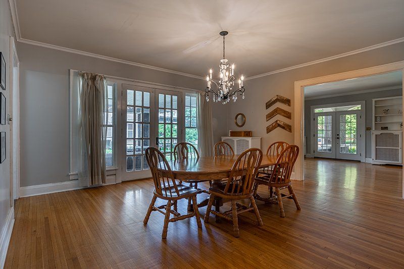 A dining room with a table and chairs and a chandelier.