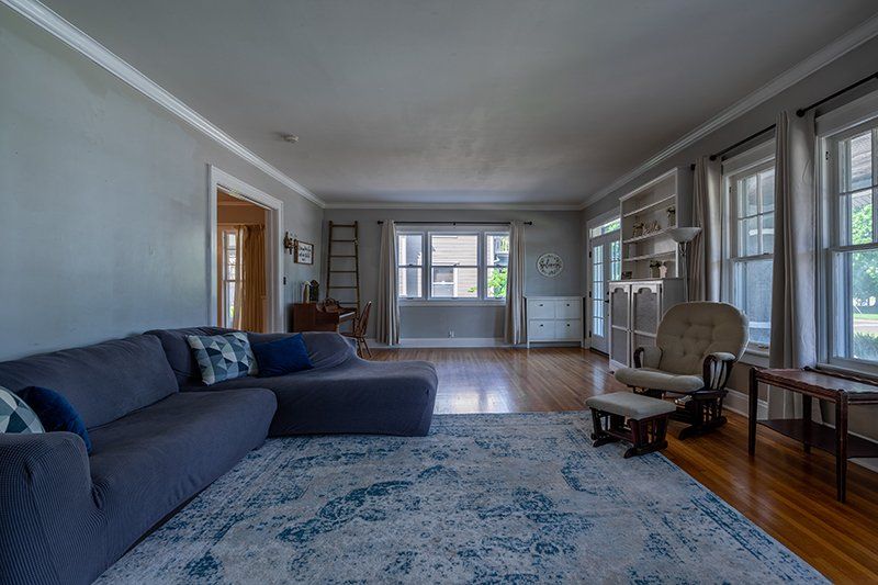 A living room with a couch , chair , and rug.