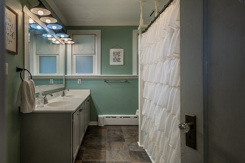 A bathroom with two sinks and a shower curtain.