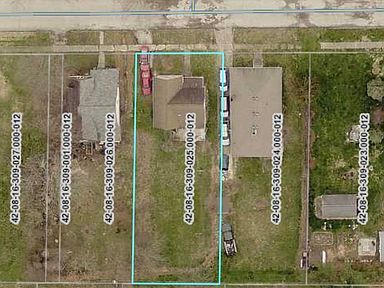 An aerial view of a residential area with houses and cars