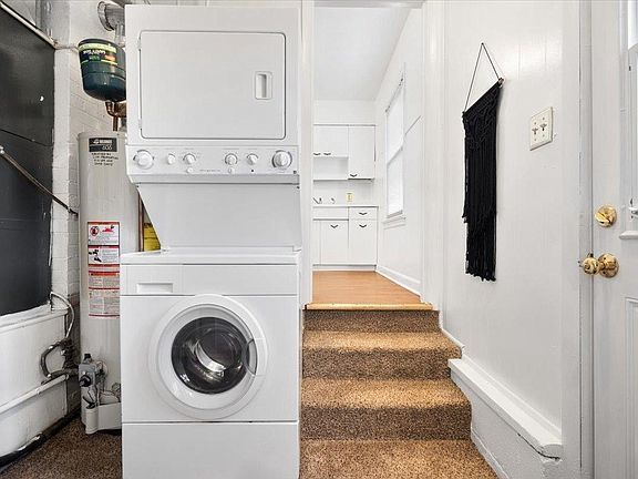 A washer and dryer are stacked on top of each other in a laundry room.