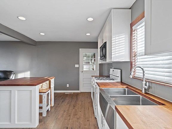 A kitchen with stainless steel appliances and wooden counter tops.