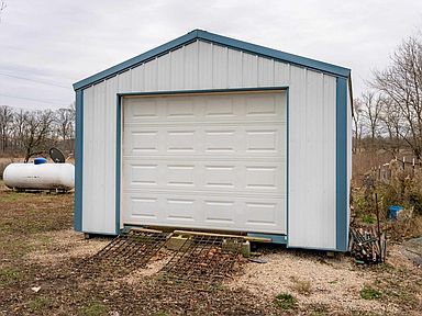 A white garage with a blue trim and a white garage door.