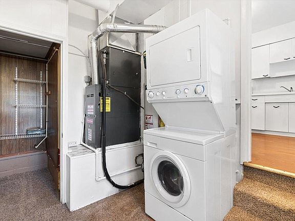 A washer and dryer are stacked on top of each other in a laundry room.
