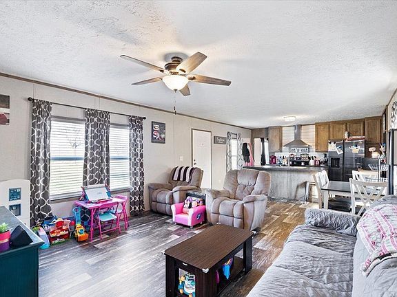 A living room filled with furniture and a ceiling fan.