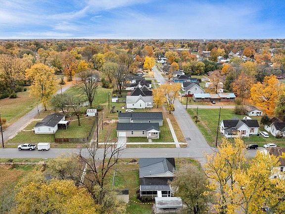 An aerial view of a residential area with houses and trees in autumn.