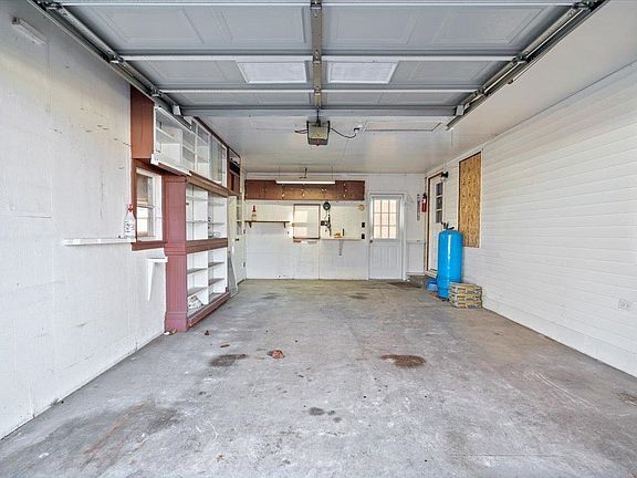 An empty garage with a garage door open.