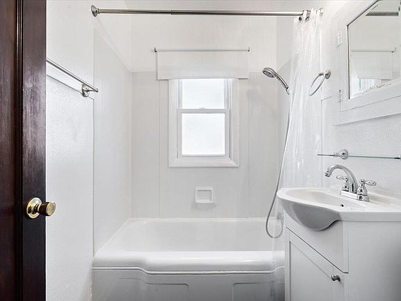 A bathroom with a sink , tub and shower.