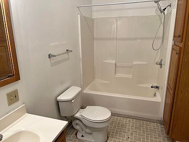 A bathroom with a toilet , sink , bathtub and shower.