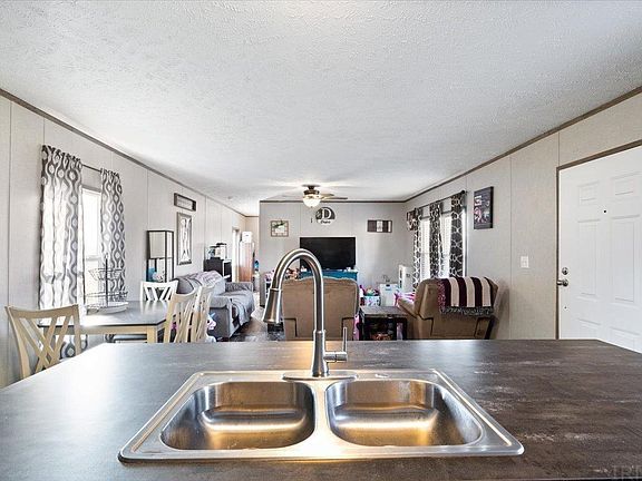 A kitchen sink is sitting on top of a counter in a house.