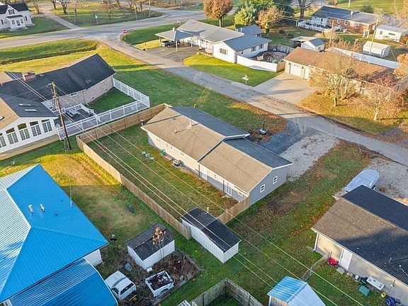 An aerial view of a residential neighborhood with lots of houses and a fence.