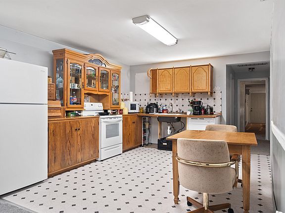 A kitchen with a table and chairs and a refrigerator.