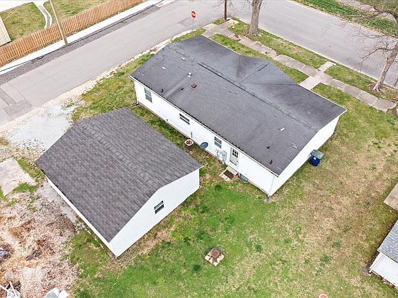 An aerial view of a house and a garage with a black roof.