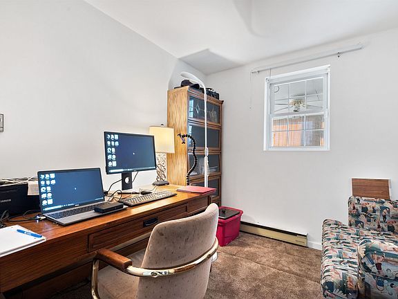 There are two computers on the desk in the room.