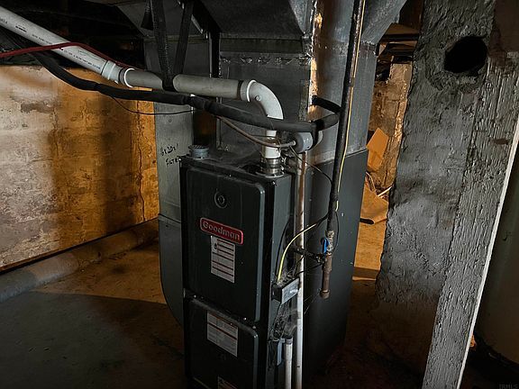 A close up of an air conditioner in a basement.