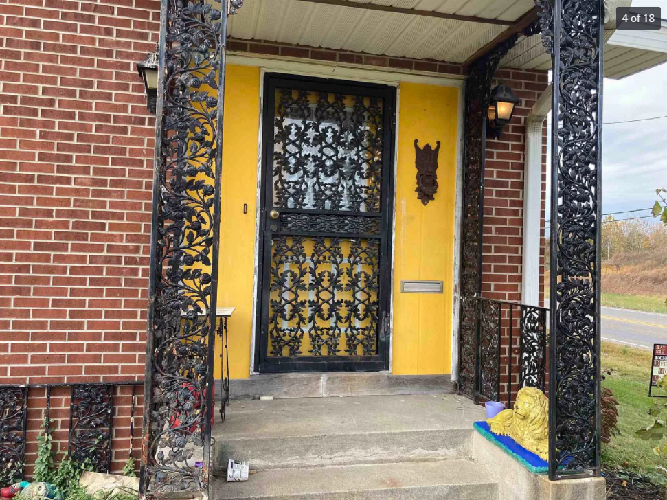 The front door of a brick house with a yellow door
