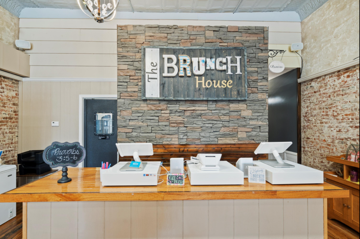 A restaurant with a wooden counter and a sign that says brunch house.