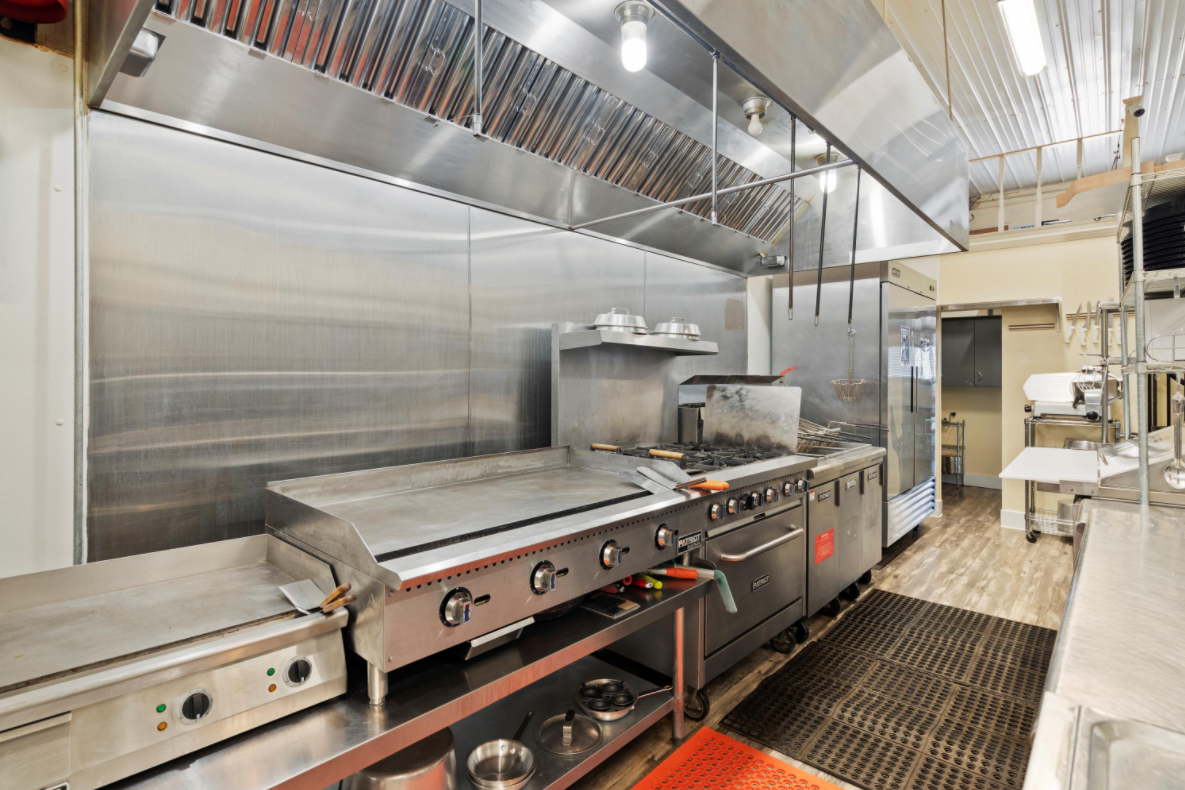 A kitchen with a lot of stainless steel appliances and a grill.