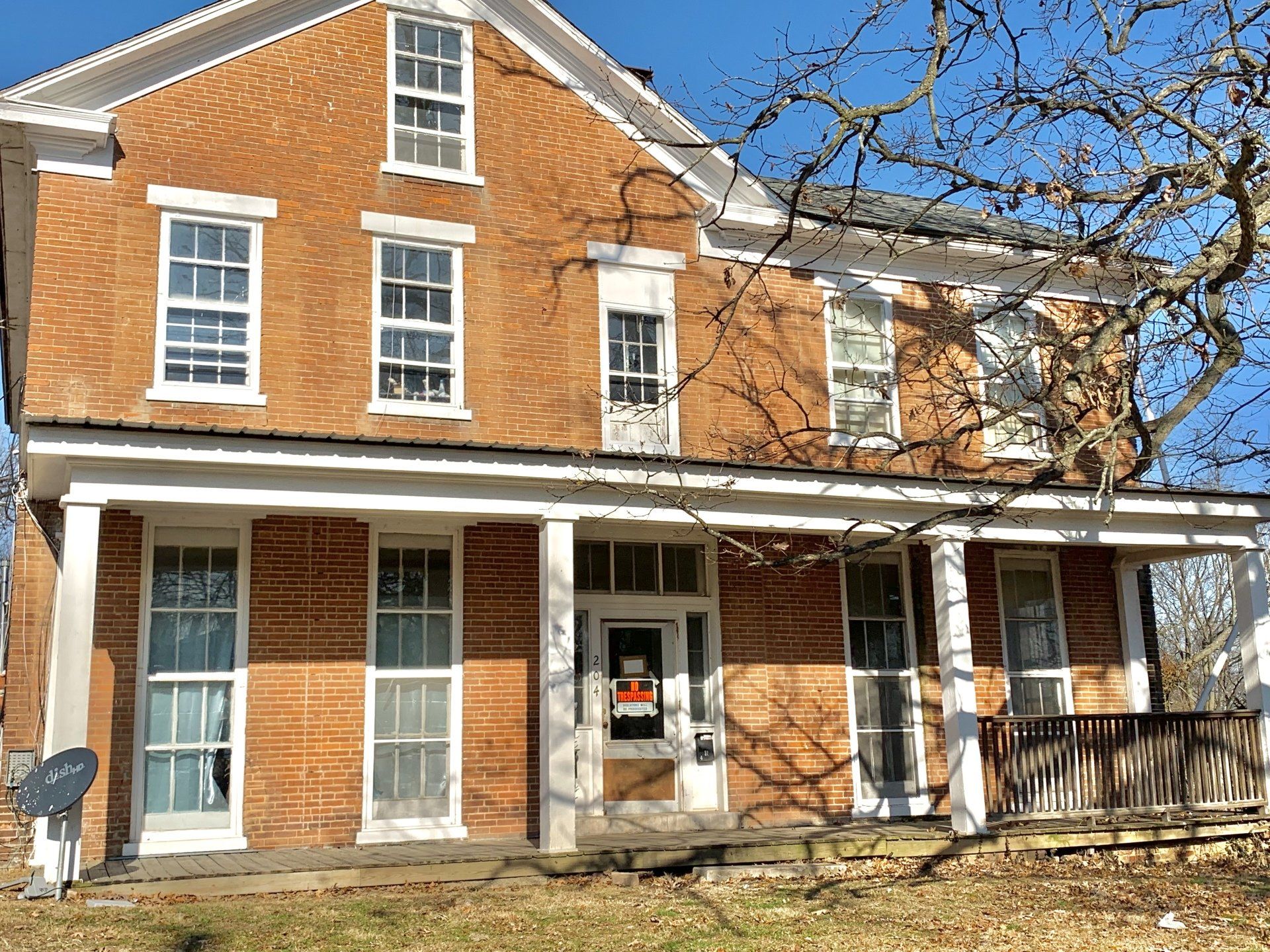 A large brick house with a porch and a lot of windows