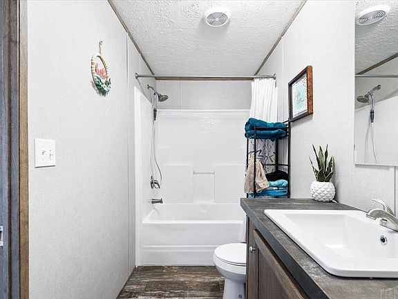 A bathroom with a sink , toilet , bathtub and mirror.